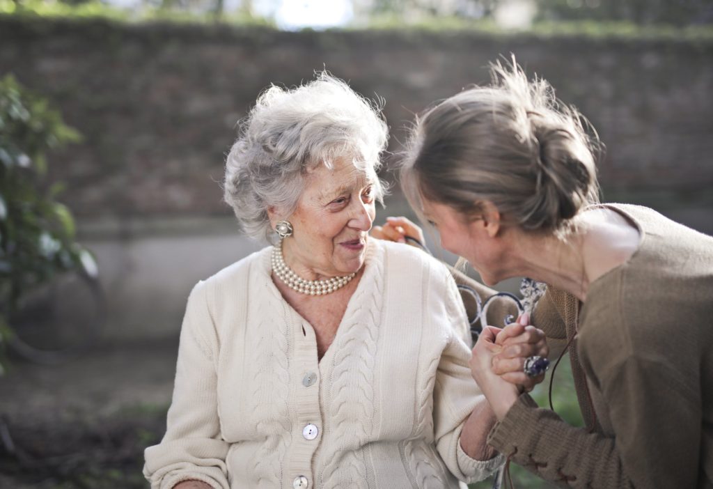 Persona mayor mostrando emociones con otro adulto